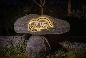 瓦亚纳德Crystal Kuruva Nature Resort & Spa的黑暗中的岩石上的标志