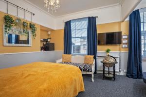 斯卡伯勒Glenholme Guest House - Room Only的一间卧室配有一张床、一把椅子和电视。