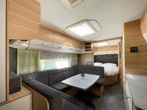 黑灵斯多夫Mietwohnwagen 01的客厅配有沙发和大篷车内的桌子