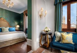 威尼斯The Gritti Palace, a Luxury Collection Hotel, Venice的一间卧室配有一张床和一张蓝色椅子