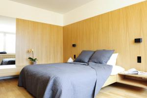 卢森堡凯帕克德梅尔公寓酒店的一间卧室配有一张带木墙的大床