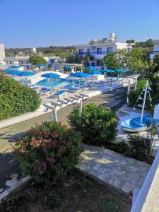 普罗塔拉斯弗罗卡斯公寓酒店的度假村内带蓝伞的游泳池