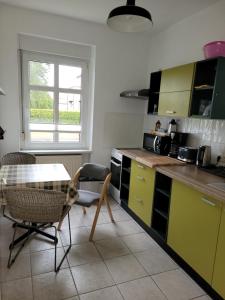 诺因哈根Carl-Schmäcke-Straße 7的厨房配有黄色橱柜和桌椅