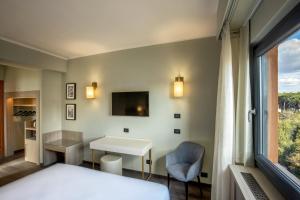 罗马马克奥雷里奥酒店的配有一张床、一张书桌和一扇窗户的酒店客房