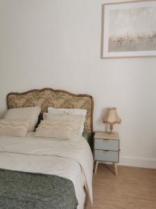 格里尼昂Au Petit Faubourg的一间卧室配有一张床和一张带台灯的桌子
