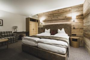 圣安东阿尔贝格施瓦泽阿德勒酒店 - 体育&Spa中心的酒店客房设有一张大床和一张沙发。