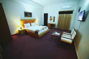 伊斯兰堡Hotel Red Line的配有一张床和一把椅子的酒店客房