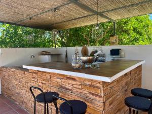 阿尔豪林德拉托里Casita Azahar Andalucia的室外厨房配有砖砌台和椅子
