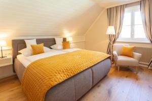 瓦豪地区魏森基兴多瑙霍夫 - 加尼酒店的一间卧室配有一张大床和一把椅子