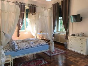 莱科天鹅别墅旅馆的一间卧室配有带窗帘的天蓬床