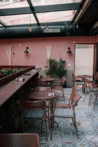 斯库台Bed Station Hostel & Bar的餐厅设有木桌、椅子和粉红色的墙壁