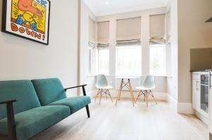 伦敦Woodview Serviced Apartments by Concept Apartments的客厅配有绿色沙发和椅子