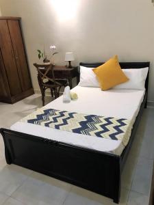 KaragampitiyaBethel Homestay的一张黑色床架和黄色枕头