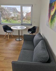 阿姆特采尔Moderne Ferienwohnung Gartenblick的客厅配有沙发、桌子和两把椅子