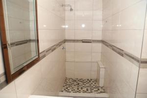 温特和克Coco Palm Bed & Breakfast的带淋浴的浴室,铺有瓷砖地板。
