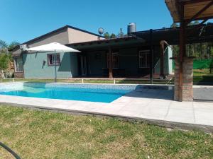 费德拉西翁Casa cabaña juanita的房屋前的游泳池