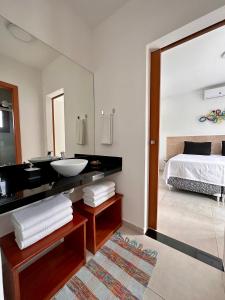 皮帕Casa Ibiza - Pipa ''Luxurious 3-Bedroom Villa with pool''的一间带水槽、床和镜子的浴室