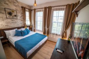 安塔利亚Sofa Hotels Kaleiçi的一间卧室配有一张带蓝色床单和窗户的床。