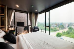 清道The View Chiang Dao Hotel的一间卧室设有一张大床和一个大窗户