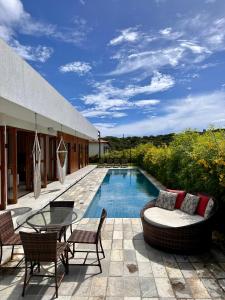 皮帕Casa Ibiza - Pipa ''Luxurious 3-Bedroom Villa with pool''的一个带桌椅的庭院和一个游泳池