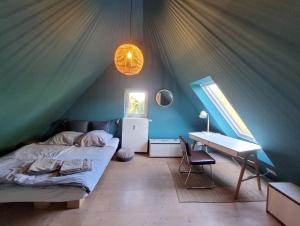 波彭豪森Landschule Rhön的一间帐篷内的卧室,配有一张床和一张书桌