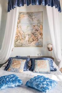 特拉西梅诺湖畔托罗Borgo Sanguineto的一张带两个枕头的床和墙上的绘画