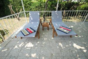卡什泰拉Villa Comfort的庭院里设有两把椅子和一张桌子
