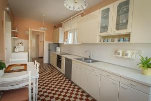 卡什泰拉Villa Comfort的厨房配有白色橱柜和 ⁇ 格地板