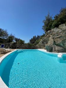 伊斯基亚Villa Marecoco的蓝色海水和岩石墙的游泳池