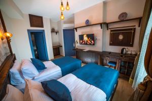 安塔利亚Sofa Hotels Kaleiçi的酒店客房设有两张床和壁炉