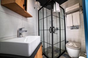 安塔利亚Sofa Hotels Kaleiçi的一间带水槽和玻璃淋浴的浴室