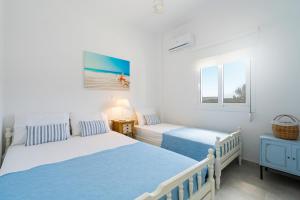 赛罗卡波斯Endless Blue的一间白色卧室,配有两张床和窗户