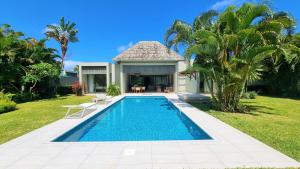 Beau ChampSuperior 4-Bedroom Villa at Anahita Golf & Spa Resort's的别墅前的游泳池