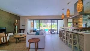 Beau ChampSuperior 4-Bedroom Villa at Anahita Golf & Spa Resort's的厨房以及带沙发和桌子的客厅。