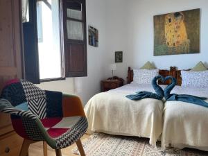 GenovésCasa Lucia的一间卧室配有一张床和一把椅子,上面配有毛巾