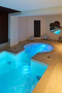 巴黎Hotel Villa Romantic & Spa的一个带椅子的房间,有一个蓝色的大游泳池