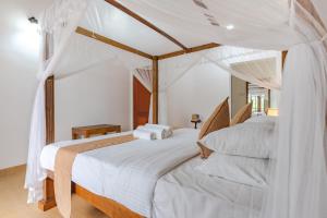 康提Villa Mount Melody的一间卧室配有两张带白色床单的床