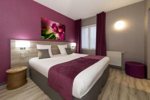 杜埃拉丰坦The Originals City, Hôtel La Saulaie, Saumur Ouest (Inter-Hotel)的一间卧室设有一张紫色墙壁的大床