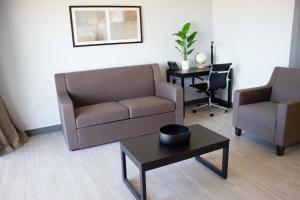 弗吉尼亚海滩Sun & Sand Resort Oceanfront Suites的客厅配有沙发、两把椅子和一张桌子