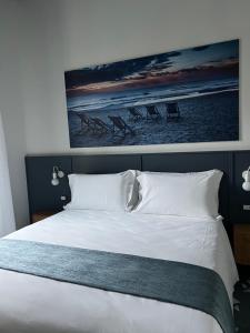 阿拉西奥Alaxia Luxury Apartments的卧室配有白色床,上面有绘画作品