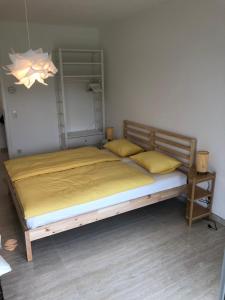 EselbornRésidence du Golf Eselborn的一间卧室配有一张带黄色床单的大床