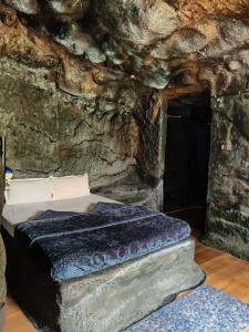 马迪凯里Rai’s Coorg Cave House的石洞里的一个床位