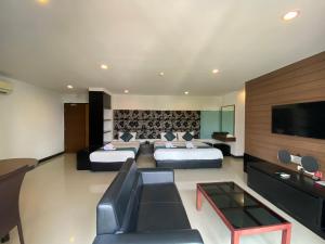 芭堤雅市中心Le Vernissage by Goad Avadhess Hospitality的酒店客房设有两张床和一台平面电视。