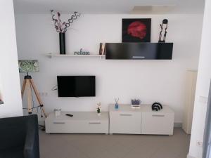 拉斯内格拉斯Apartamento Viento Del Sur的一间带电视和白色橱柜的客厅
