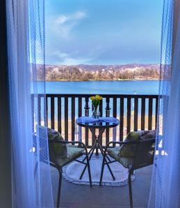 OstrovoAdonis的湖景阳台配有桌椅
