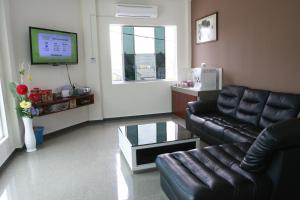 马六甲阿罗尔别墅的客厅配有真皮沙发和电视