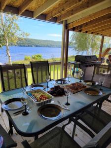 Rivière-RougeSheldon Cozy on Lake Cottage with Private Jacuzzi的一张带食物和酒杯的蓝色桌子