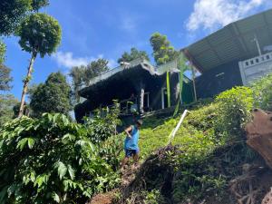 马迪凯里Rai’s Coorg Cave House的站在房子前面的人