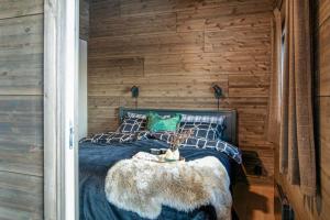 奥耶New ap The Nest in Hafjell ski in out and fast Wifi的一间卧室配有一张带仿毛皮桌子的床