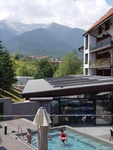 班斯科Bansko St Ivan Rilski Luxury Apartment 4 stars Free SPA & Mineral water的一群人在一座山地游泳池里